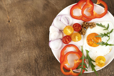 Healthy breakfast in the morning with fried egg and vegetables on white plate. copy space.