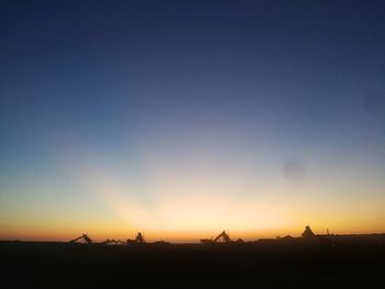 Silhouette landscape against clear sky during sunset