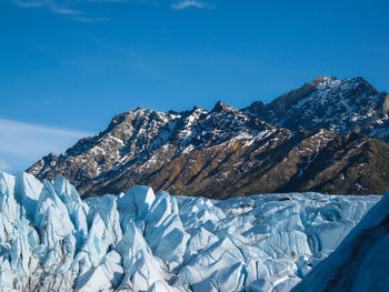 Glacial seracs of matanuska glacier in foreground, snow dusted mountains in background