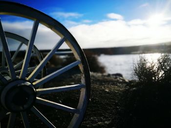 Close-up of wheel by road against sky