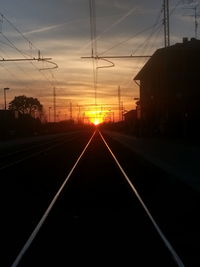 Railroad tracks against sky during sunset