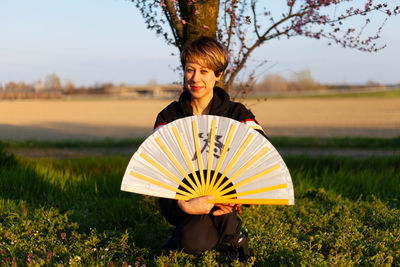 Young caucasian woman posing a wushu martial art posture in a sunny day, a pink tree in background