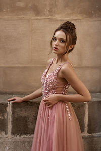 Young woman standing against wall