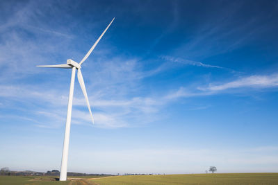 Low angle view of windturbinel on field against sky