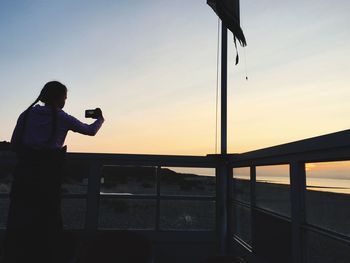 Full length of man photographing at sunset