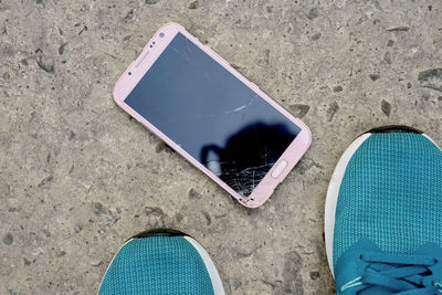 Low section of person using mobile phone on beach