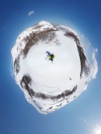 Little planet format of man on snowcapped mountain against sky