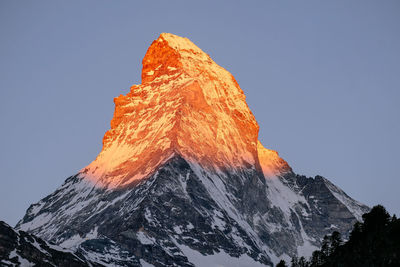 Low angle view of snowcapped mountain against clear sky