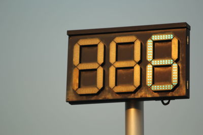 Low angle view of illuminated lighting equipment against clear sky