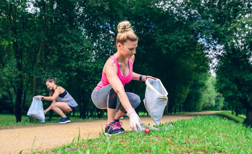 Female friends picking garbage at park