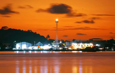 Illuminated street lights against sky at night