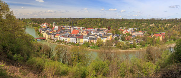 High angle view of buildings by trees against sky