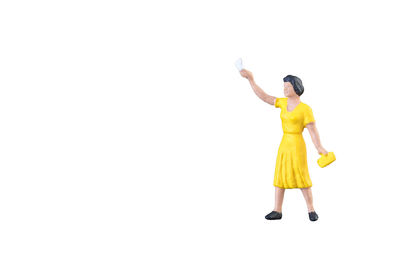 Full length of woman holding yellow while standing against white background