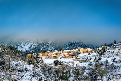 High angle view of trees and buildings against sky during winter