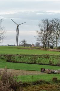 Windmill on field against sky