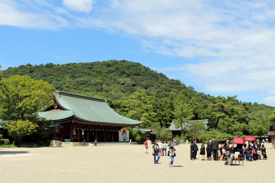 Group of people in front of built structure against sky