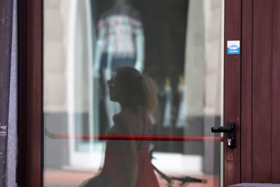 Rear view of woman looking through window