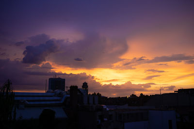 Silhouette buildings against sky during sunset