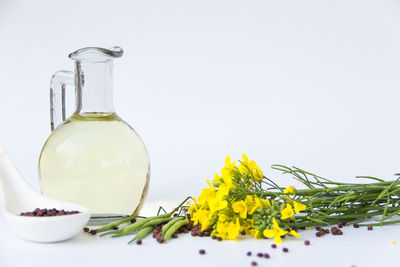 Close-up of yellow rose in glass bottle on table