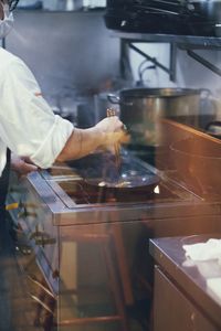 Midsection of chef preparing food in kitchen