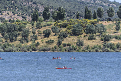 A large group of canoeists in a lake surrounded by beautiful mountainous landscape.