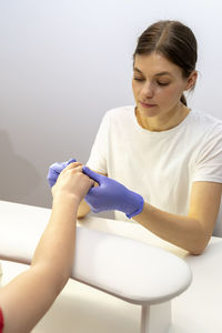 Portrait of smiling young woman exercising against white background