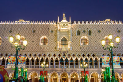 Low angle view of illuminated building against blue sky