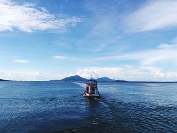 Boat sailing on sea against sky