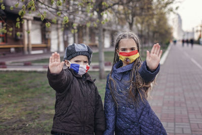 Portrait of kids wearing mask standing outdoors