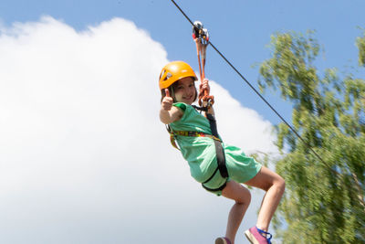 Adventure climbing high wire park - people on course in mountain helmet and safety equipment