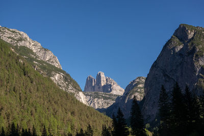 Low angle view of panoramic shot of mountains against clear blue sky