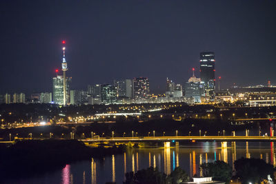 Illuminated buildings in city against sky at night