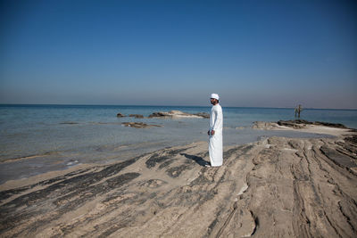 Full length of man on beach against clear sky