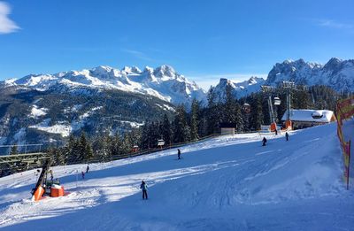 People skiing on snowcapped mountain against sky