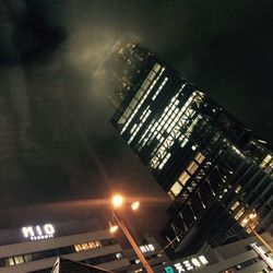 Low angle view of illuminated skyscraper against sky at night