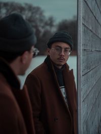 Portrait of young man wearing hat standing in winter