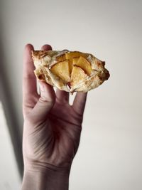 Midsection of person holding ice cream cone against white background