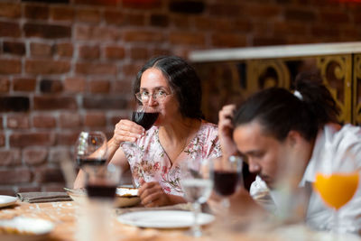 Portrait of woman drinking glass in restaurant