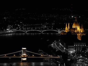 Illuminated bridge over river at night