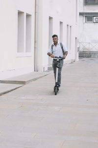 Casual businessman riding e-scooter in the city