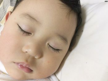 Close-up of boy sleeping on bed