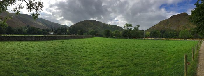 Panoramic view of green landscape and mountains against sky