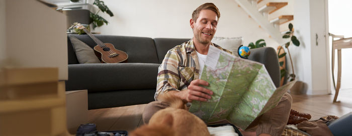 Young man using mobile phone while sitting on sofa at home