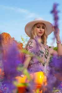 Young woman standing by flowering plants