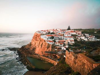 High angle view of townscape by sea against sky