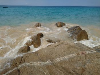 Scenic view of rocks on beach against sky