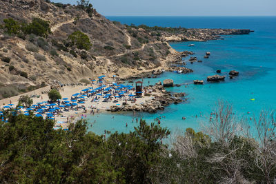 High angle view of sea by mountains against clear blue sky