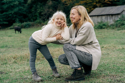 Cheerful carefree mother and little daughter on a walk in the farm.