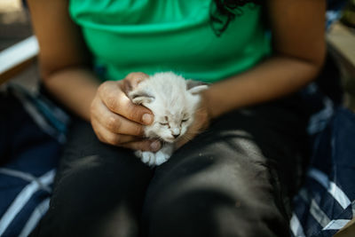Midsection of woman with cat sitting on floor
