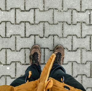 Low section of man standing on cobblestone